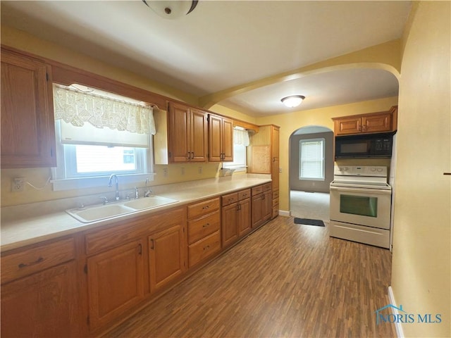 1007 Leonard Ct, Fostoria, OH 44830 - kitchen with electric range, black microwave, arched walkways, wood finished floors, and healthy amount of natural light