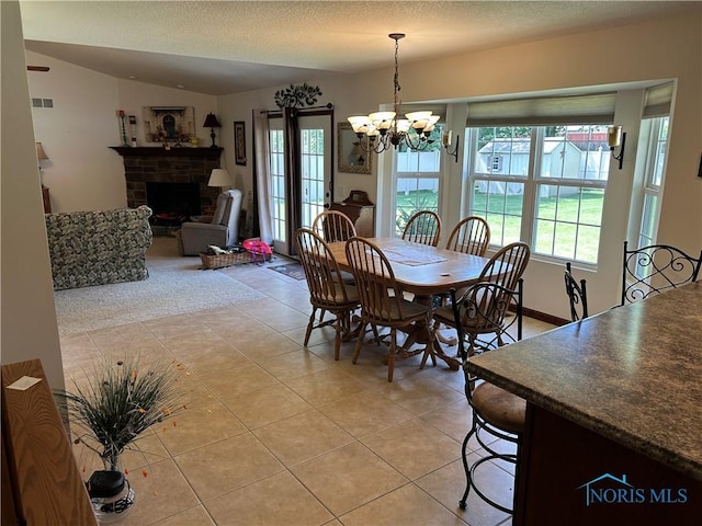 2440 Bluestone Dr, Findlay, OH 45840 - dining space featuring light tile patterned flooring, a chandelier, a brick fireplace, and a textured ceiling