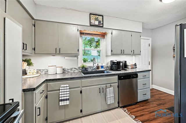 634 Cherry St, Findlay, OH 45840 - kitchen with appliances with stainless steel finishes, dark countertops, dark wood finished floors, a textured ceiling, and gray cabinets