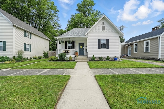 634 Cherry St, Findlay, OH 45840 - view of front facade with covered porch, a front yard, and a shingled roof