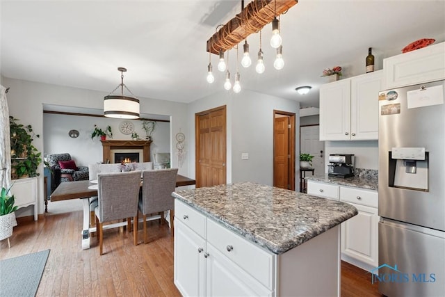 2393 Woods Edge Rd, Perrysburg, OH 43551 - kitchen with stainless steel fridge with ice dispenser, a kitchen island, light wood-style flooring, and white cabinetry