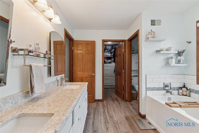 2393 Woods Edge Rd, Perrysburg, OH 43551 - full bath featuring wood finished floors, a garden tub, and double vanity