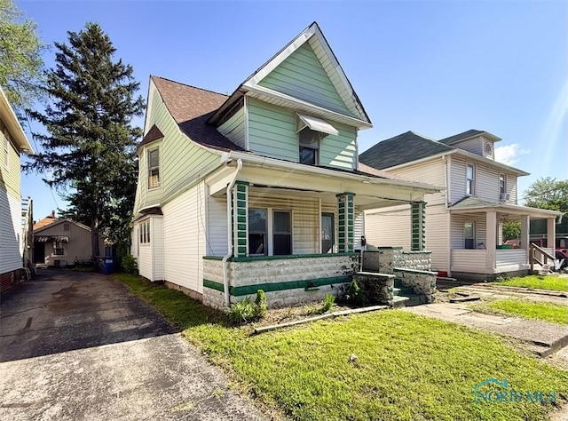 1534 Indiana Ave, Toledo, OH 43607 - view of front of house featuring a porch, asphalt driveway, and a front yard