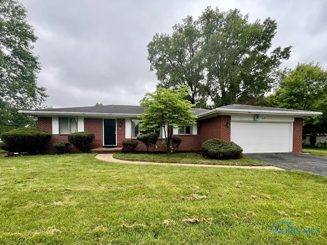 4409 Merry Ln, Toledo, OH 43615 - ranch-style home featuring asphalt driveway, a garage, brick siding, and a front yard