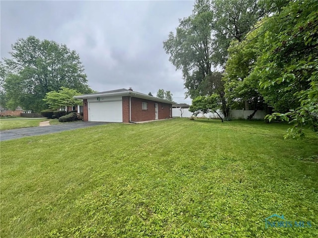 4409 Merry Ln, Toledo, OH 43615 - view of yard with asphalt driveway and an attached garage