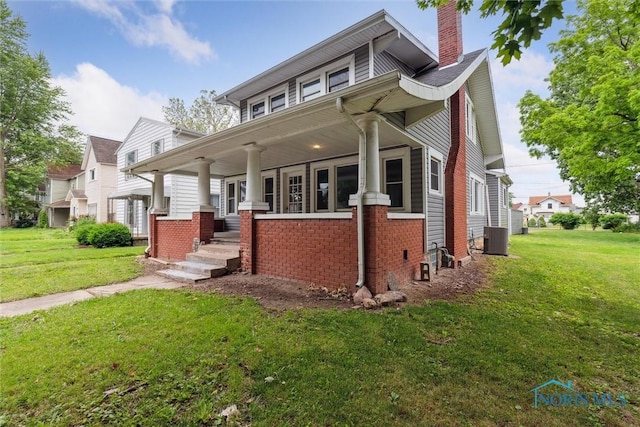 108 Western Ave, Findlay, OH 45840 - view of front of home with brick siding, covered porch, a chimney, and a front yard