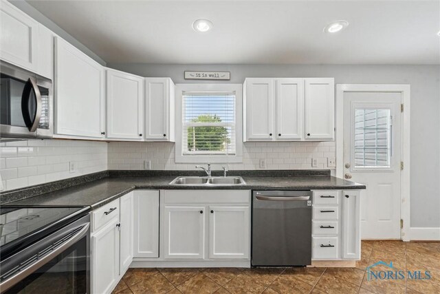 108 Western Ave, Findlay, OH 45840 - kitchen featuring appliances with stainless steel finishes, dark countertops, white cabinets, backsplash, and recessed lighting