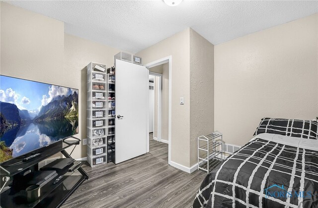 616 Normandie Blvd, Bowling Green, OH 43402 - bedroom with wood finished floors, a textured ceiling, and a textured wall