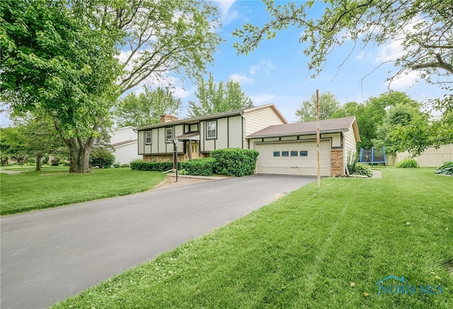 616 Normandie Blvd, Bowling Green, OH 43402 - split foyer home featuring a trampoline, a chimney, driveway, and a front yard