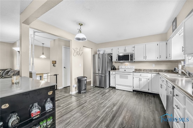 616 Normandie Blvd, Bowling Green, OH 43402 - kitchen with stainless steel appliances, dark wood-style floors, white cabinets, light countertops, and a textured ceiling