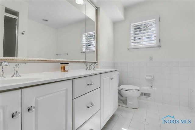 3998 W Bancroft St, Ottawa Hills, OH 43606 - full bath with double vanity, tile patterned floors, an enclosed shower, and tile walls