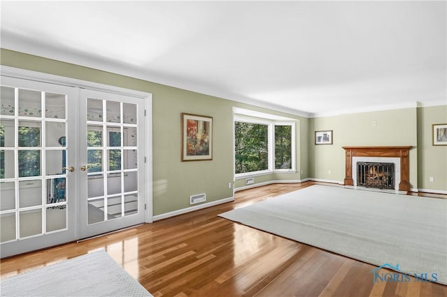 3998 W Bancroft St, Ottawa Hills, OH 43606 - unfurnished living room featuring wood finished floors, a warm lit fireplace, and french doors