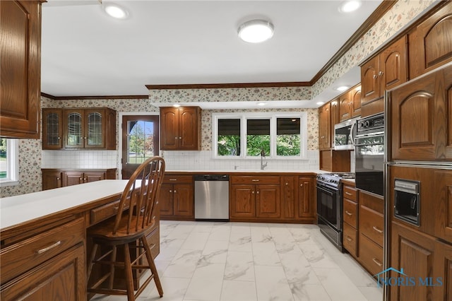 3998 W Bancroft St, Ottawa Hills, OH 43606 - kitchen featuring stainless steel appliances, light marble finish floors, light countertops, crown molding, and recessed lighting