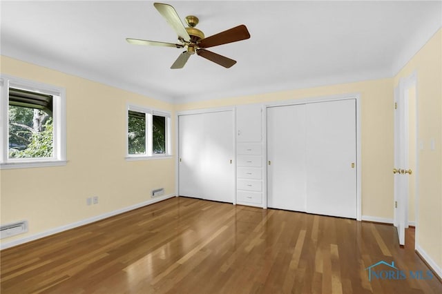 3998 W Bancroft St, Ottawa Hills, OH 43606 - unfurnished bedroom with multiple closets, wood finished floors, and a ceiling fan