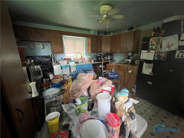 2017 Newport Ave, Toledo, OH 43613 - kitchen with freestanding refrigerator, a ceiling fan, brown cabinets, and light flooring