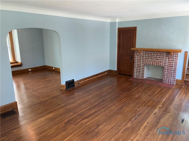 4033 Eastway St, Toledo, OH 43612 - unfurnished living room featuring wood finished floors, arched walkways, and a fireplace