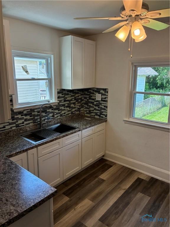 4033 Eastway St, Toledo, OH 43612 - kitchen with white cabinets, decorative backsplash, and dark wood finished floors