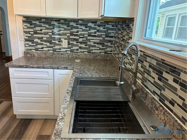 4033 Eastway St, Toledo, OH 43612 - kitchen view of white cabinetry, backsplash, and wood finished floors