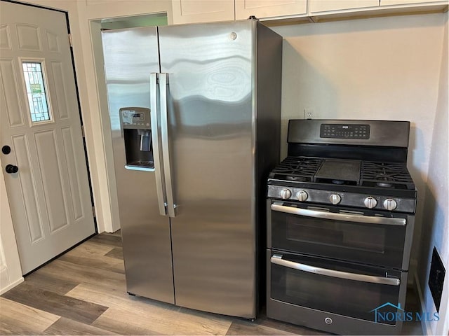 4033 Eastway St, Toledo, OH 43612 - kitchen with appliances with stainless steel finishes, white cabinets, and light wood-style flooring