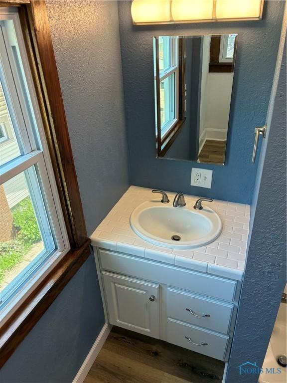 4033 Eastway St, Toledo, OH 43612 - bathroom with vanity, wood finished floors, and a textured wall