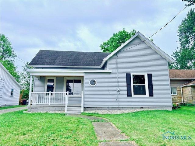 127 W Maumee Ave, Napoleon, OH 43545 - bungalow-style home with covered porch, a front yard, and a shingled roof