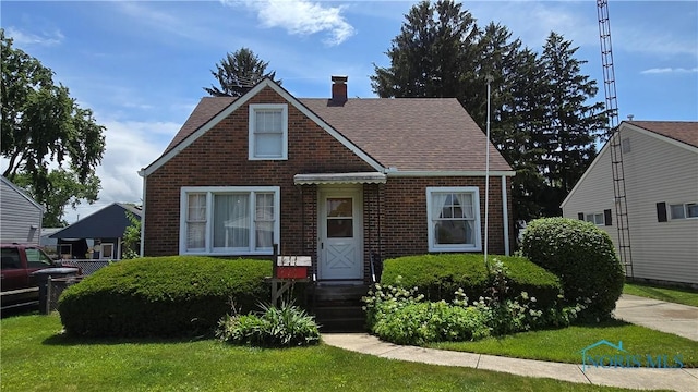 2632 117th St, Toledo, OH 43611 - bungalow-style home featuring brick siding, a chimney, a shingled roof, and a front lawn