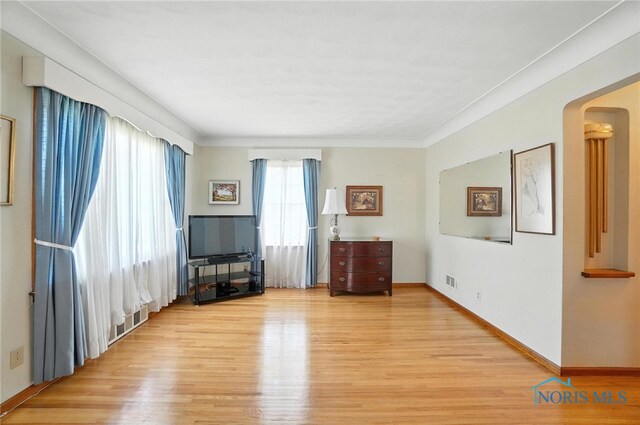 2632 117th St, Toledo, OH 43611 - living room featuring light wood finished floors, arched walkways, and ornamental molding