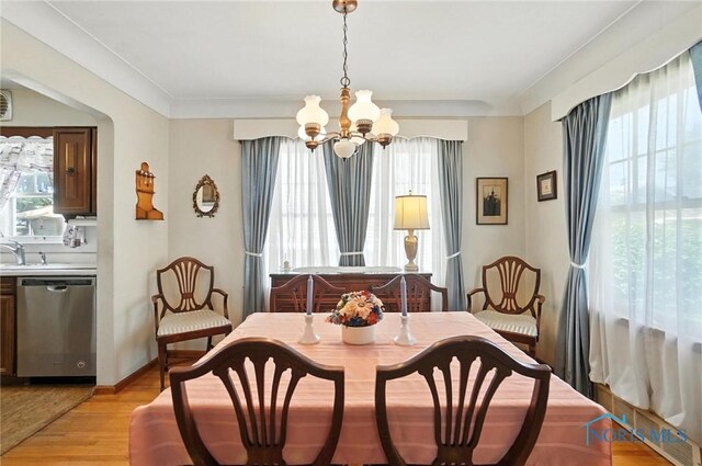 2632 117th St, Toledo, OH 43611 - dining room featuring healthy amount of natural light, a chandelier, light wood-type flooring, and ornamental molding