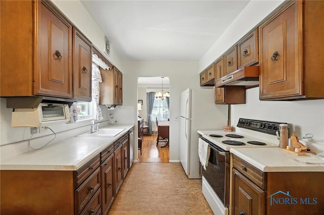 2632 117th St, Toledo, OH 43611 - kitchen featuring white appliances, under cabinet range hood, plenty of natural light, and light countertops