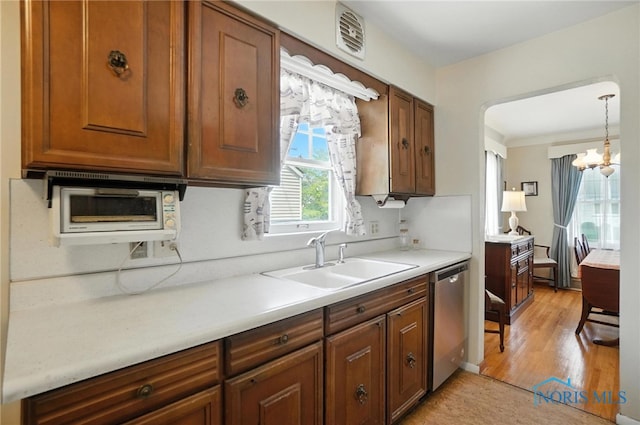 2632 117th St, Toledo, OH 43611 - kitchen featuring stainless steel dishwasher, light countertops, a chandelier, and light wood-style floors