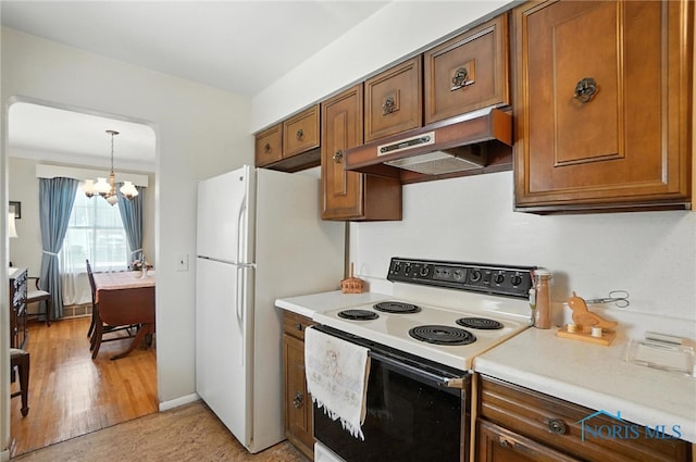 2632 117th St, Toledo, OH 43611 - kitchen featuring white appliances, under cabinet range hood, brown cabinetry, light countertops, and a chandelier