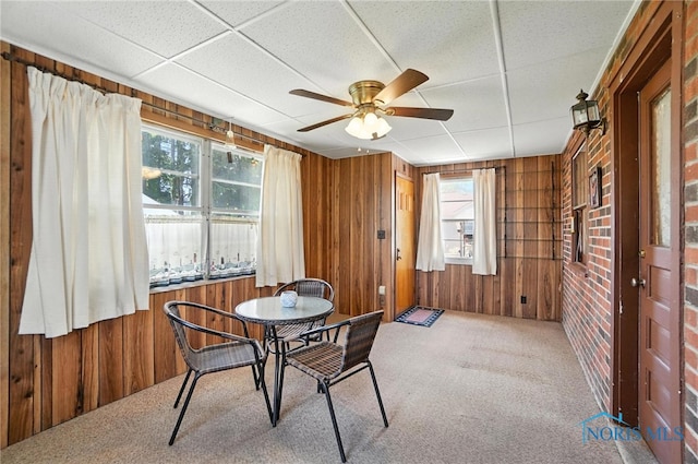 2632 117th St, Toledo, OH 43611 - carpeted dining area with wooden walls and a ceiling fan