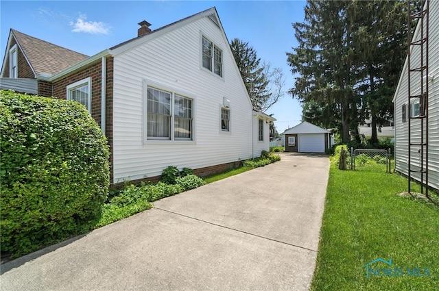 2632 117th St, Toledo, OH 43611 - view of home's exterior featuring a garage, an outbuilding, and a chimney