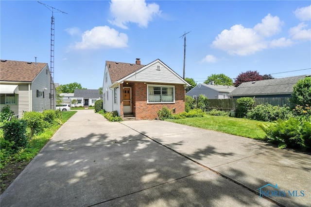 2632 117th St, Toledo, OH 43611 - view of front of home with brick siding, a chimney, and driveway