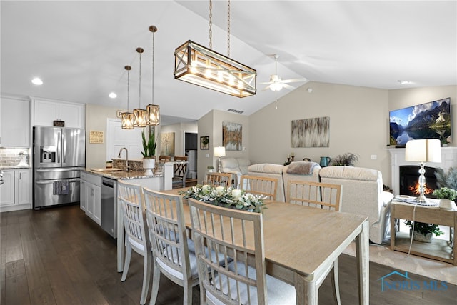 4825 Sylvan Prairie Ct, Sylvania, OH 43560 - dining area featuring a ceiling fan, dark wood-style floors, a warm lit fireplace, lofted ceiling, and recessed lighting