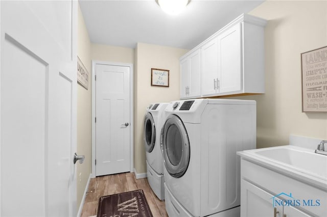 4825 Sylvan Prairie Ct, Sylvania, OH 43560 - laundry area with washing machine and dryer, cabinet space, and light wood finished floors