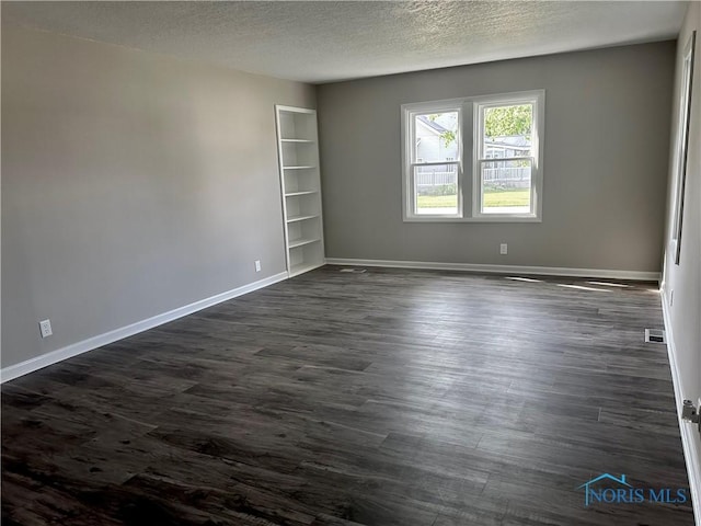 101 S Madison St, Antwerp, OH 45813 - spare room with dark wood-type flooring, a textured ceiling, and built in shelves
