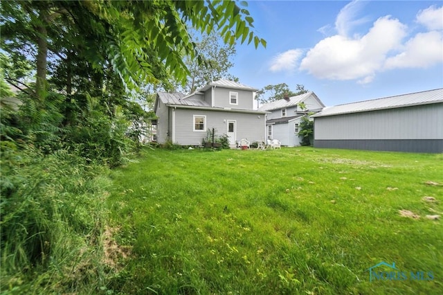 407 Washington St, Findlay, OH 45840 - back of property featuring a lawn, a metal roof, a standing seam roof, and an outbuilding