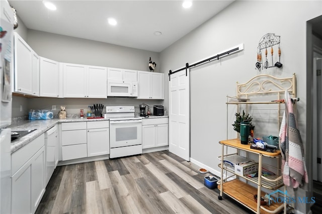 407 Washington St, Findlay, OH 45840 - kitchen featuring white appliances, recessed lighting, a barn door, white cabinets, and light wood-style floors