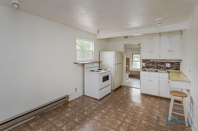 5712 Rambo Ln, Toledo, OH 43623 - kitchen with white appliances, baseboard heating, healthy amount of natural light, light countertops, and a textured ceiling