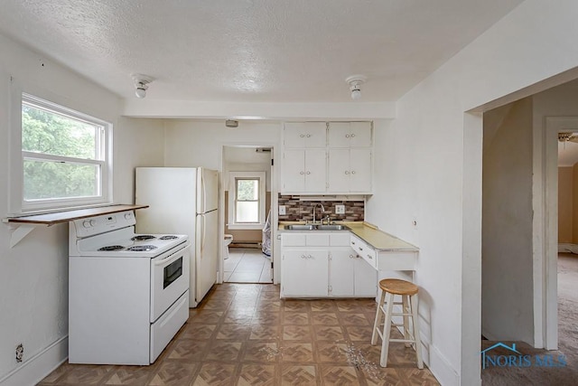 5712 Rambo Ln, Toledo, OH 43623 - kitchen with white appliances, tasteful backsplash, white cabinets, a textured ceiling, and light countertops