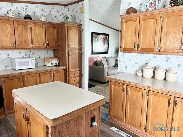 120 E Nicholas St, Arlington, OH 45814 - kitchen with white microwave, wallpapered walls, dark wood-style floors, light countertops, and vaulted ceiling