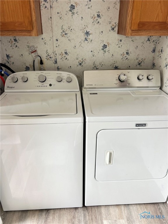 120 E Nicholas St, Arlington, OH 45814 - laundry area with cabinet space, wallpapered walls, separate washer and dryer, and wood finished floors