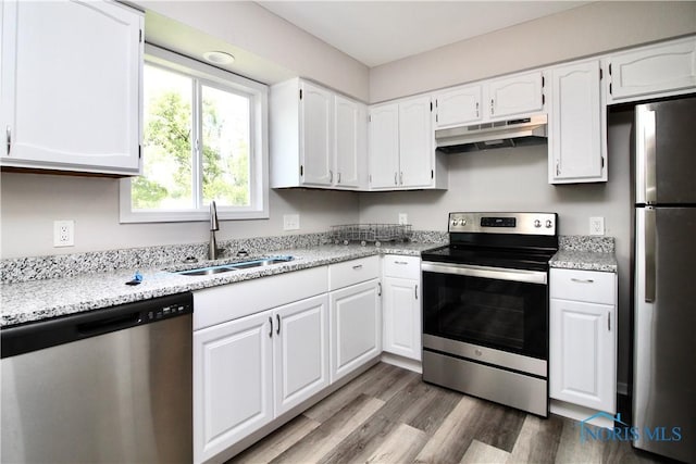 6182 Old Farm Ct, Toledo, OH 43612 - kitchen featuring appliances with stainless steel finishes, under cabinet range hood, wood finished floors, white cabinets, and light stone counters