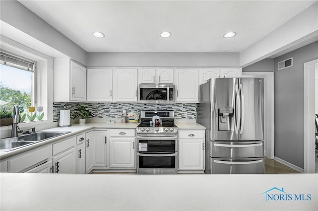 772 Fairway Ln, Wauseon, OH 43567 - kitchen featuring appliances with stainless steel finishes, decorative backsplash, white cabinets, light countertops, and recessed lighting