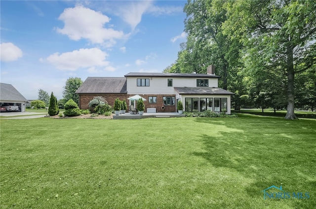 772 Fairway Ln, Wauseon, OH 43567 - back of property featuring a chimney, brick siding, a sunroom, a yard, and roof with shingles