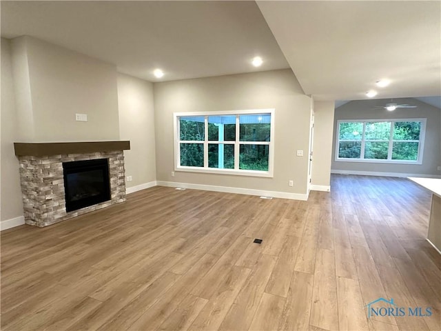 7811 Sonoma Dr, Monclova, OH 43542 - unfurnished living room featuring wood finished floors, a stone fireplace, and a ceiling fan
