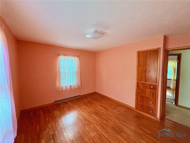 237 Pontious Pl, Napoleon, OH 43545 - spare room featuring a baseboard heating unit and wood finished floors