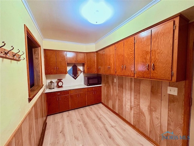 237 Pontious Pl, Napoleon, OH 43545 - kitchen featuring black microwave, brown cabinets, light wood finished floors, ornamental molding, and light countertops