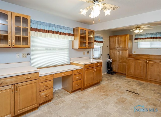 564 Southfield Dr, Maumee, OH 43537 - kitchen with built in desk, ceiling fan, light countertops, and brown cabinetry
